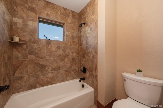 bathroom with tiled shower / bath combo and toilet