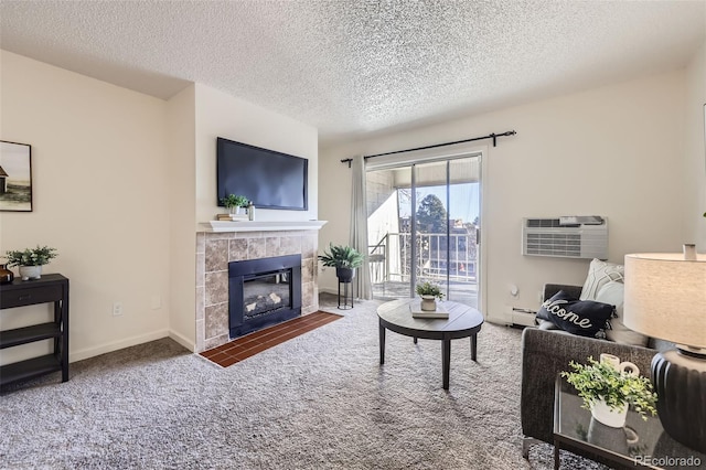 carpeted living room featuring a textured ceiling, an AC wall unit, a tile fireplace, and a baseboard radiator