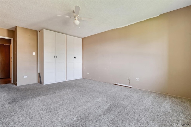 unfurnished bedroom featuring a textured ceiling, carpet flooring, and ceiling fan