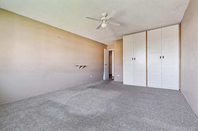 unfurnished bedroom with a textured ceiling, carpet, ceiling fan, and a closet