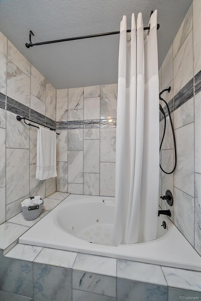 bathroom featuring a textured ceiling and a combined bath / shower with jetted tub