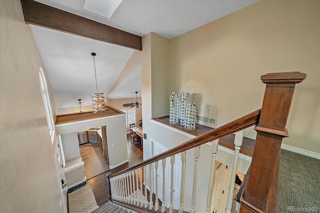 stairway featuring visible vents, ceiling fan, baseboards, lofted ceiling with beams, and wood finished floors