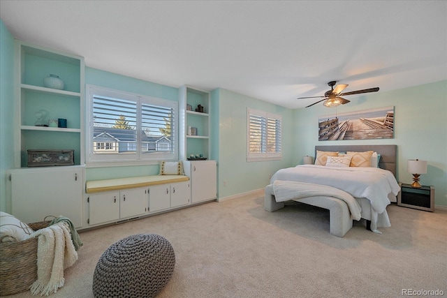 bedroom featuring light colored carpet, baseboards, and ceiling fan