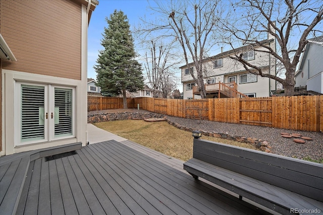 deck with a fenced backyard and french doors