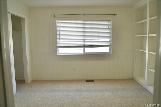 4788 Laurelglen Ln, Highlands Ranch, CO 80130 - unfurnished bedroom featuring wainscoting, light colored carpet, multiple windows, and a closet