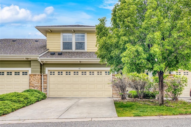3000 E 112th Ave Unit 86, Northglenn, CO 80233 - view of front of property with driveway, an attached garage, a shingled roof, and stone siding