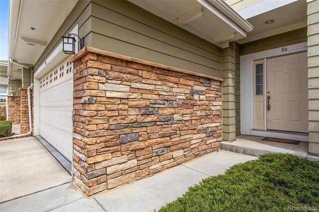 3000 E 112th Ave Unit 86, Northglenn, CO 80233 - property entrance featuring stone siding and a garage