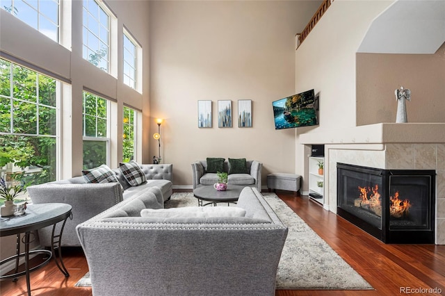 3000 E 112th Ave Unit 86, Northglenn, CO 80233 - living area with a towering ceiling, a glass covered fireplace, and dark wood-style flooring