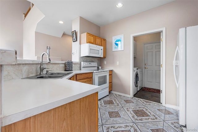3000 E 112th Ave Unit 86, Northglenn, CO 80233 - kitchen featuring white appliances, a sink, washing machine and clothes dryer, light countertops, and tasteful backsplash