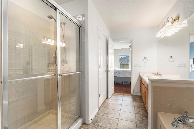 3000 E 112th Ave Unit 86, Northglenn, CO 80233 - ensuite bathroom featuring a stall shower, vanity, a textured ceiling, baseboards, and ceiling fan