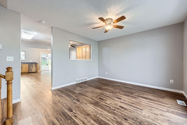 empty room featuring visible vents, wood finished floors, baseboards, and ceiling fan
