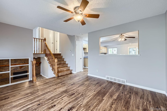 unfurnished living room with a ceiling fan, baseboards, visible vents, and wood finished floors