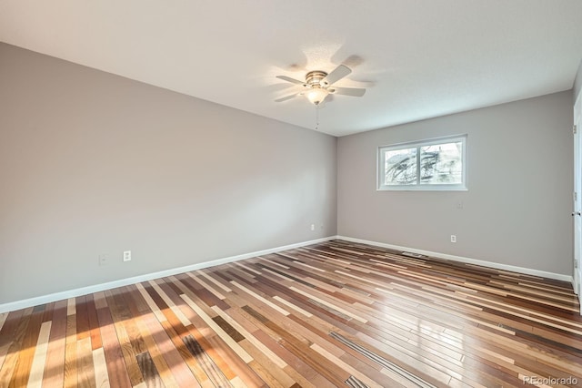 unfurnished room with baseboards, a ceiling fan, and wood-type flooring