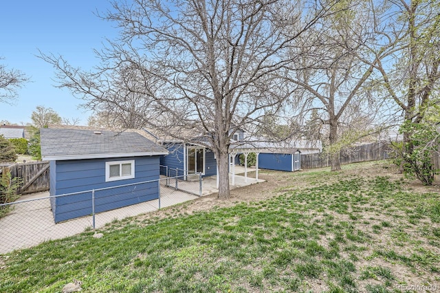 view of yard featuring a fenced backyard, a shed, and an outbuilding