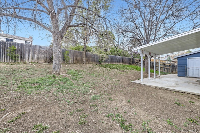 view of yard featuring a fenced backyard, a patio area, and an outbuilding