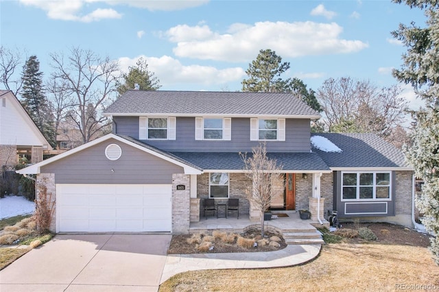 traditional home featuring driveway, a shingled roof, an attached garage, and brick siding