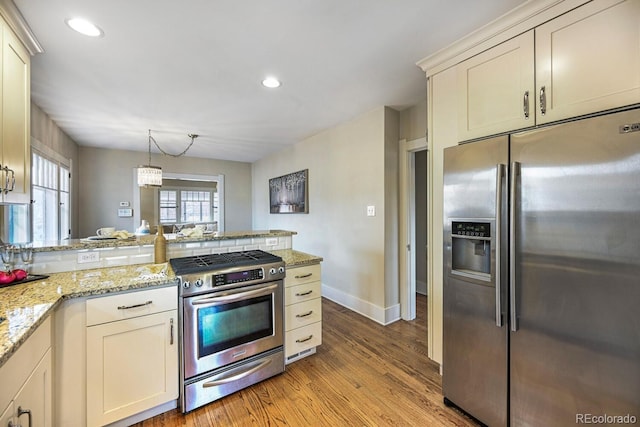 kitchen with appliances with stainless steel finishes, a peninsula, light stone countertops, light wood-type flooring, and recessed lighting