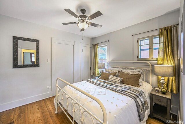 bedroom with wood finished floors, a ceiling fan, and baseboards