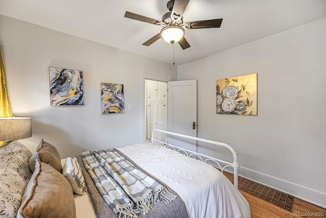 bedroom with ceiling fan, baseboards, and wood finished floors