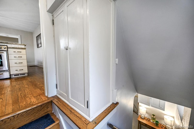 hall featuring wood finished floors and baseboards