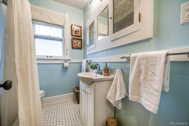 full bath with toilet, vanity, baseboards, and tile patterned floors