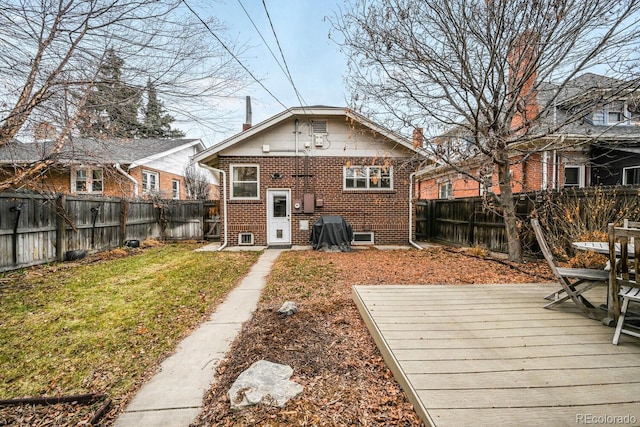 back of property featuring a yard, a fenced backyard, and brick siding