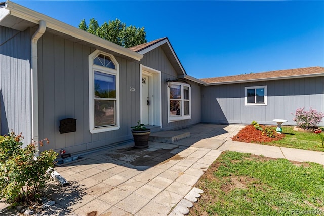 entrance to property featuring a shingled roof