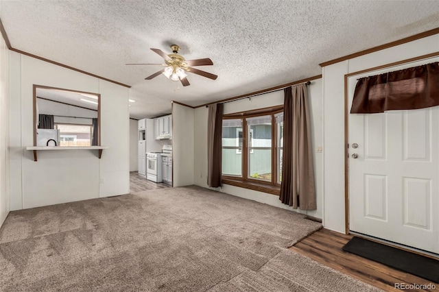 unfurnished living room with ceiling fan, crown molding, a textured ceiling, healthy amount of natural light, and light wood-style flooring