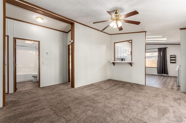 unfurnished living room with ceiling fan, carpet, a textured ceiling, and crown molding