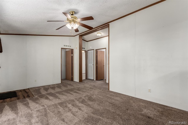 carpeted spare room featuring crown molding, ceiling fan, a textured ceiling, and lofted ceiling