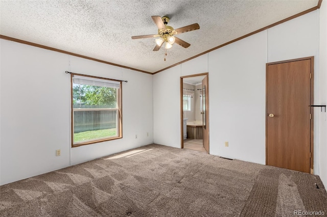 unfurnished bedroom with ornamental molding, carpet floors, vaulted ceiling, a textured ceiling, and ensuite bathroom