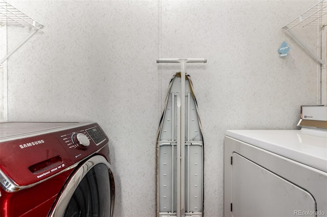 clothes washing area with washing machine and clothes dryer