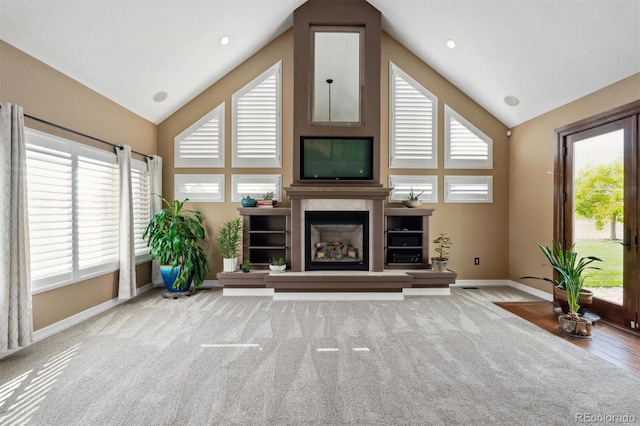 29850 E 167th Pl, Brighton, CO 80603 - unfurnished living room featuring high vaulted ceiling, baseboards, plenty of natural light, and a glass covered fireplace