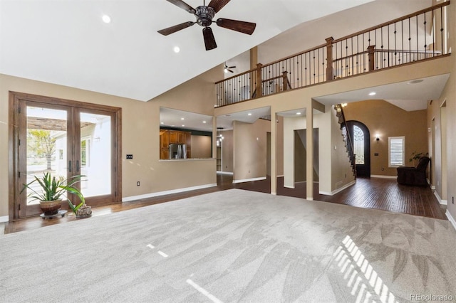 unfurnished living room with french doors, ceiling fan, high vaulted ceiling, and dark hardwood / wood-style flooring