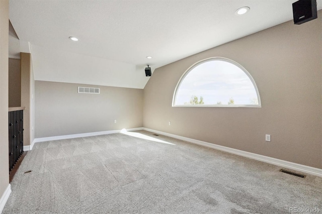 empty room featuring light carpet and vaulted ceiling