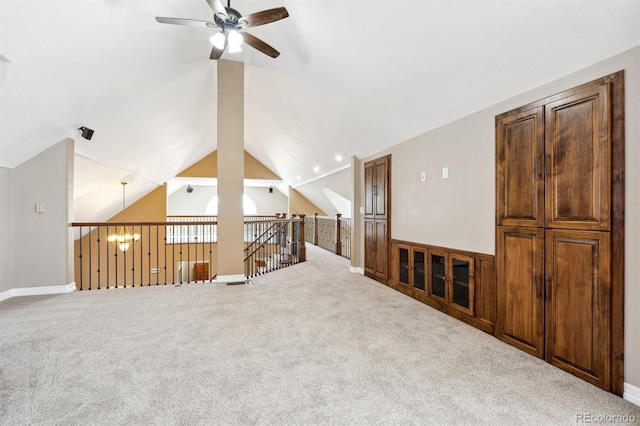 carpeted spare room with lofted ceiling and ceiling fan with notable chandelier