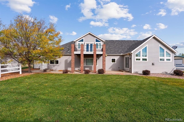 view of front of house with a balcony, a front yard, and a patio area