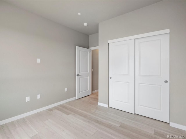 unfurnished bedroom with a closet and light hardwood / wood-style floors