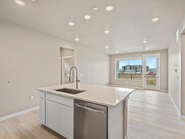 kitchen featuring stainless steel dishwasher, sink, a center island with sink, light hardwood / wood-style floors, and white cabinetry