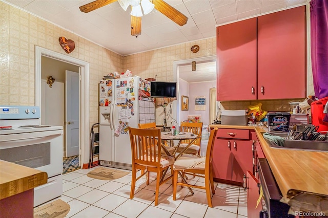 2421 N York St, Denver, CO 80205 - kitchen with red cabinets, white appliances, a ceiling fan, wallpapered walls, and a sink