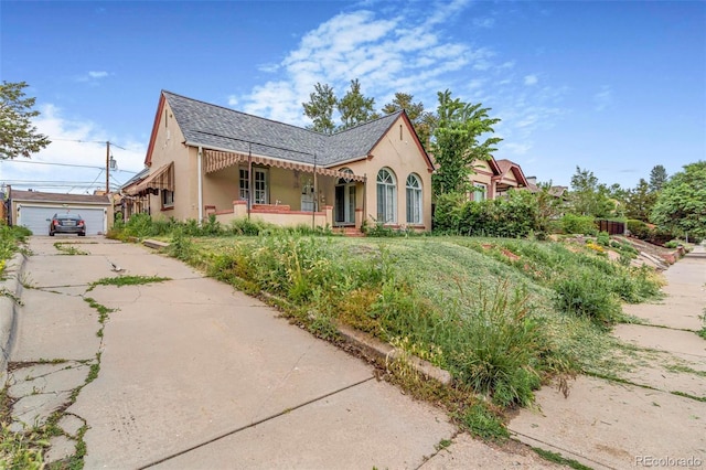 2421 N York St, Denver, CO 80205 - view of front of property featuring stucco siding, an outdoor structure, driveway, and roof with shingles