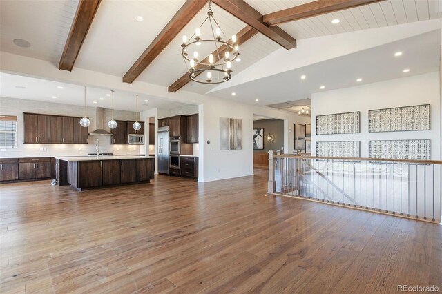 27381 E Lakeview Dr, Aurora, CO 80016 - unfurnished living room with a chandelier, a sink, beamed ceiling, wood finished floors, and recessed lighting