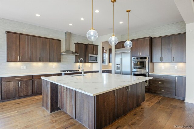 27381 E Lakeview Dr, Aurora, CO 80016 - kitchen with wall chimney exhaust hood, built in appliances, decorative backsplash, dark brown cabinetry, and recessed lighting