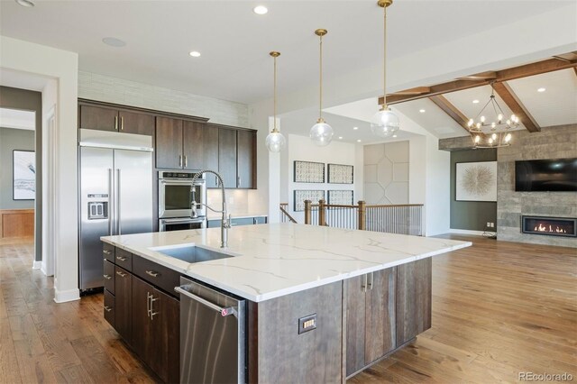 27381 E Lakeview Dr, Aurora, CO 80016 - kitchen with stainless steel appliances, wood finished floors, dark brown cabinetry, baseboards, and recessed lighting