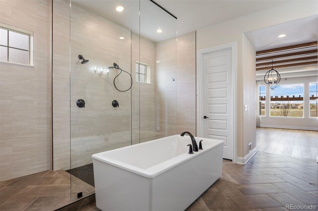 27381 E Lakeview Dr, Aurora, CO 80016 - bathroom featuring healthy amount of natural light, walk in shower, a freestanding tub, a chandelier, and recessed lighting
