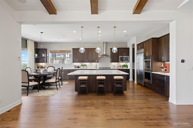 27381 E Lakeview Dr, Aurora, CO 80016 - kitchen featuring built in appliances, wall chimney exhaust hood, dark brown cabinetry, light countertops, and beam ceiling