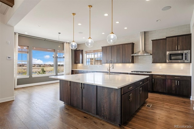 27381 E Lakeview Dr, Aurora, CO 80016 - kitchen featuring appliances with stainless steel finishes, wall chimney range hood, dark wood-style floors, a large island, and recessed lighting