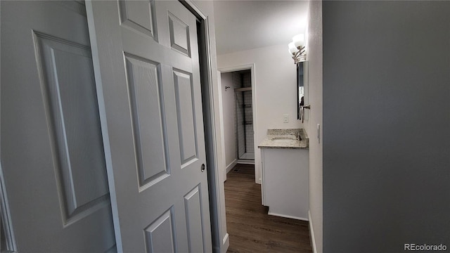 hall with dark wood-type flooring and a sink