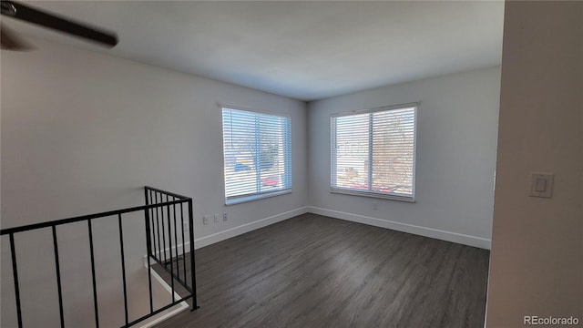 empty room with dark wood finished floors and baseboards