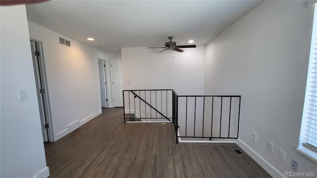 unfurnished room featuring dark wood-style flooring, recessed lighting, visible vents, a ceiling fan, and baseboards